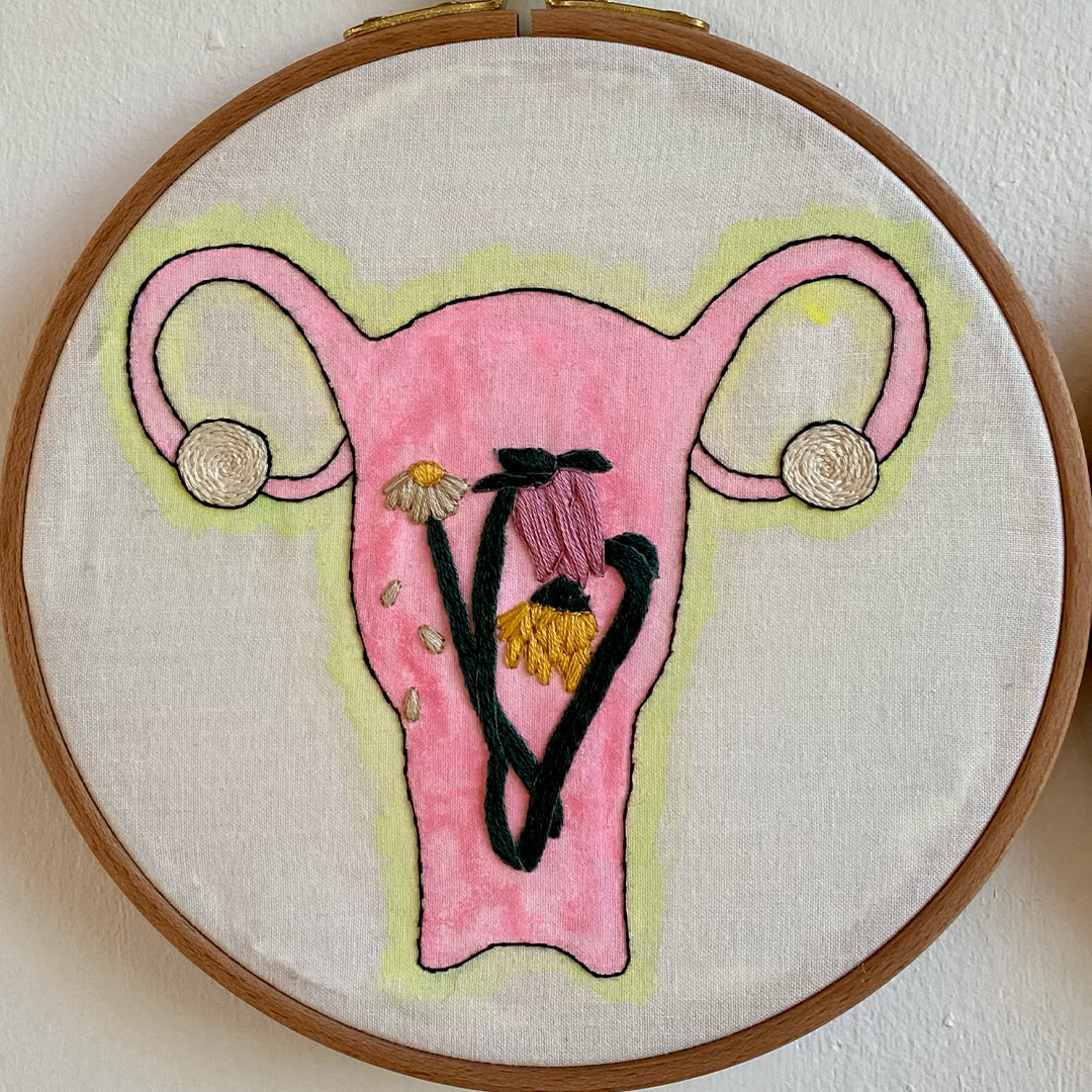 an embroidery of a uterus with wilted flowers