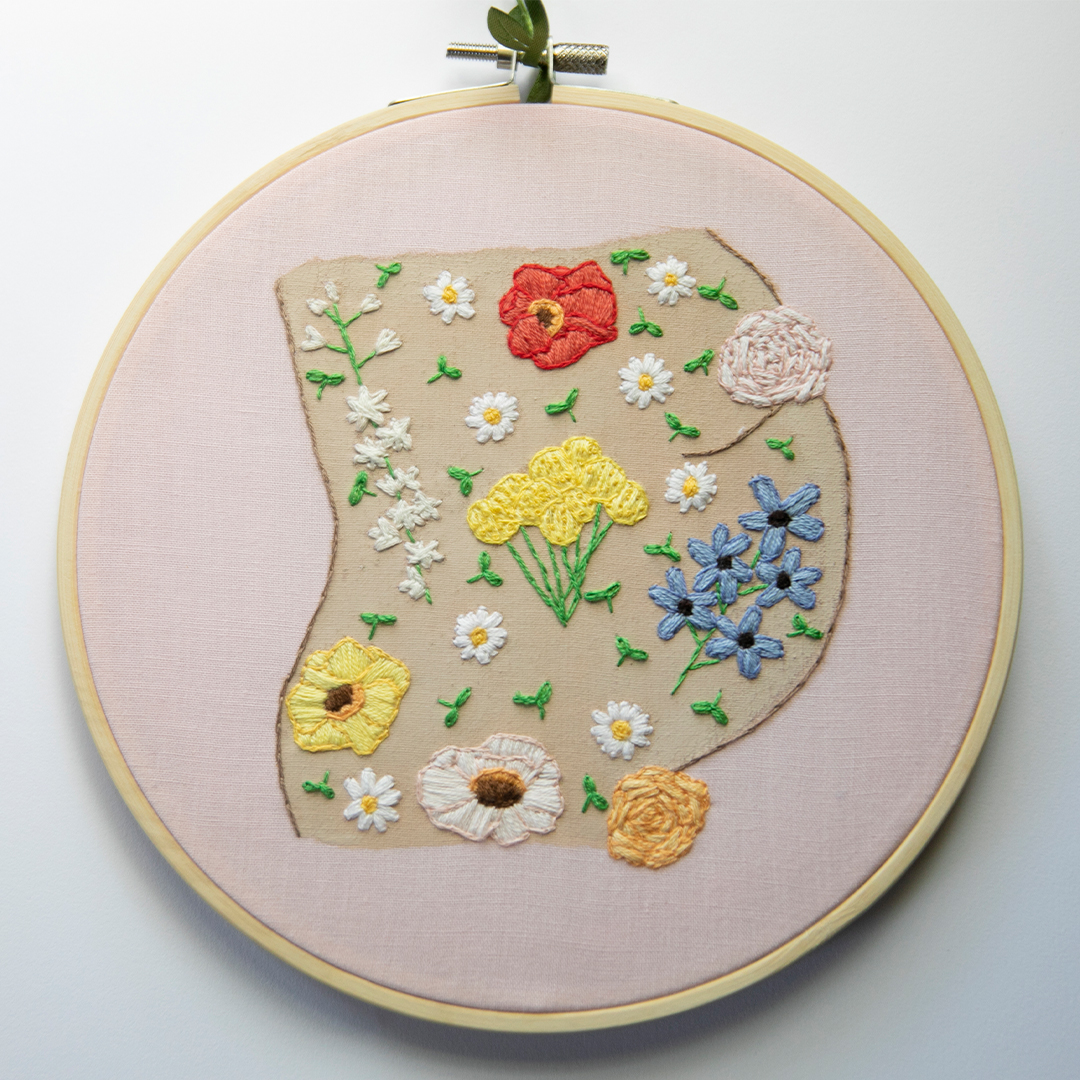an embroidery of a nude torso covered in flowers